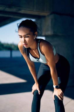 Genç atletik kadın şehirde koşarken yorgun ve dinleniyor. Spor konsepti                     