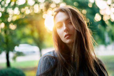 Yeşil arka planda genç ve güzel bir kadın yaz doğası. Portreyi kapat