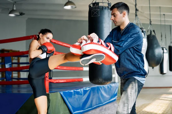 Vrouwelijke Bokser Kick Bokshandschoenen Gehouden Door Personal Trainer Fitnessruimte Gezond — Stockfoto