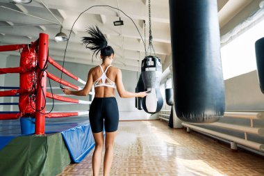 Spor salonunda ip atlayan fitness kadınının arka görüntüsü. Kardiyo ve fitness egzersizi. Spor konsepti           