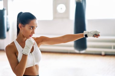 Boks stüdyosunda boks antrenmanı yapan bir bayan boksör. Atletik kadın direkt vuruş yapıyor. Spor konsepti                          