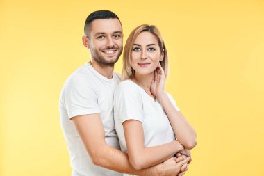 Sarı arka planda kucaklaşan mutlu genç çift. İlişki kavramı                     