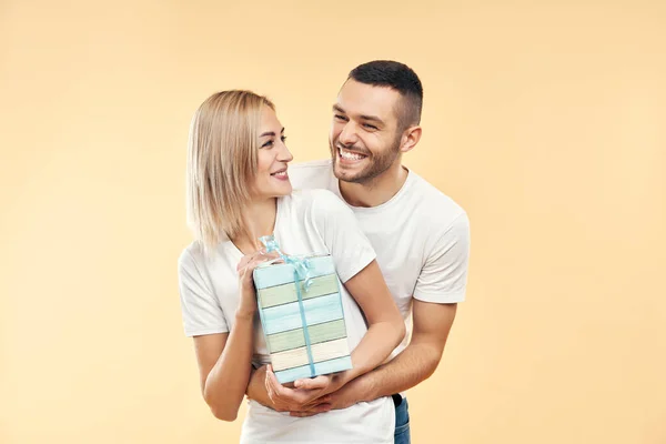 Jovem Casal Feliz Com Caixa Presente Sobre Fundo Bege Presente — Fotografia de Stock