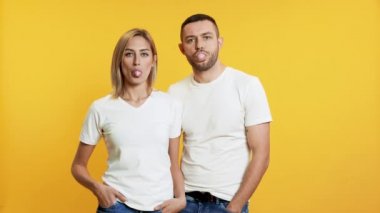 Sarı arka planda sakız çiğneyen güzel bir çiftin görüntüleri.