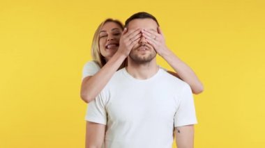 Sarı arka planda beyaz tişörtlü güzel bir çiftin portresi