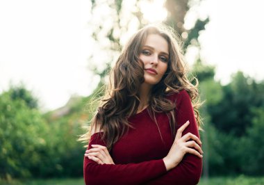 Yeşil yaz arka planında karşıdan karşıya geçen kendine güvenen güzel bir kadının portresi. Kadın güzellik konsepti                            