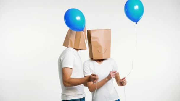 带着纸袋的年轻夫妇头上挂着气球跳舞 有趣的政党概念 — 图库视频影像