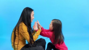 Mutlu genç anne ve tatlı kızı pasta oynayıp birlikte eğleniyorlar.