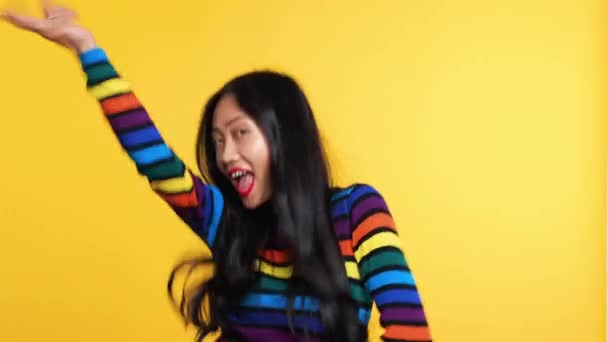 Азійка кумедно танцює на жовтому фоні — стокове відео