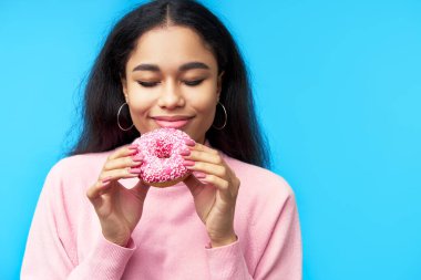 Baştan çıkarıcı yemek. Güzel siyahi kadın donuttan hoşlanır.
