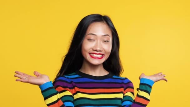 Bonita mujer asiática posando sobre fondo amarillo — Vídeo de stock