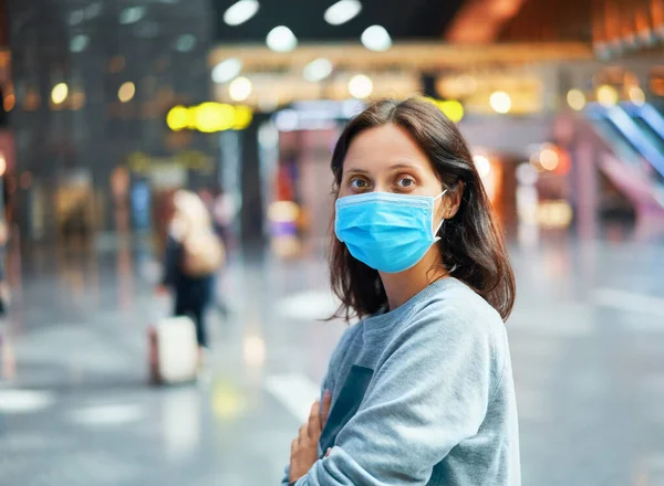 Virüs korumalı gezgin kadın uluslararası havaalanında maske takıyor.