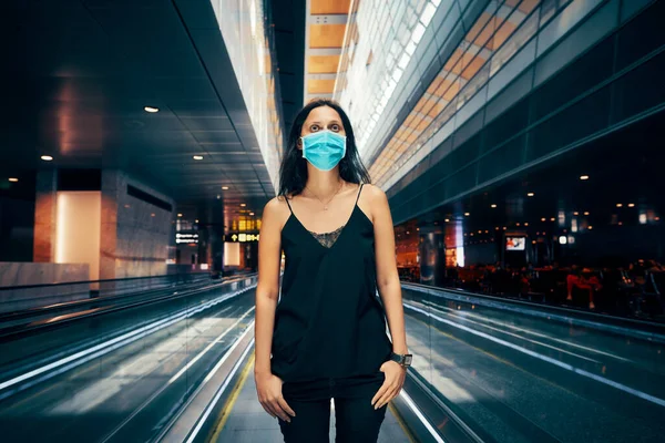 Woman in protection face mask posing in modern shopping mall or airport — Stock Photo, Image