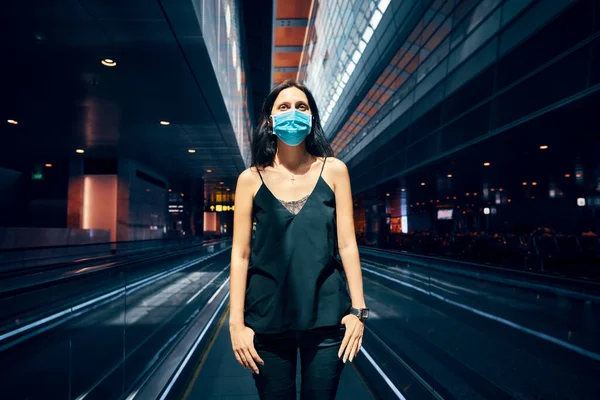 Woman in protection face mask posing in modern shopping mall or airport — Stock Photo, Image