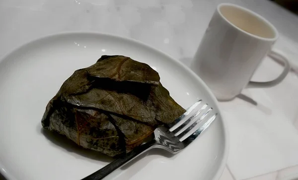 Lo mai gai dibungkus dan disajikan dalam piring, dengan garpu dan cangkir kopi — Stok Foto