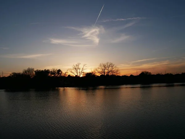 Silhouettes coucher de soleil au bord d'un lac — Photo