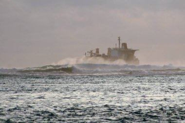 Büyük kızgın dalgalar küçük bir gemi denizde fırtınalı bir günde rock.
