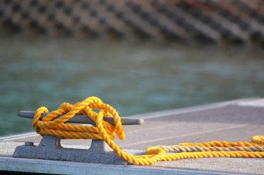 Dock cihazına bağlı bir tekne için bekleyen bir moor yeni sarı ip parçası bağlı