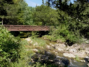 Geçit iz yürüyüşçüler için hizmet veren küçük bir dere yukarıda yapılandırdığınız bir kırmızı ahşap köprü.