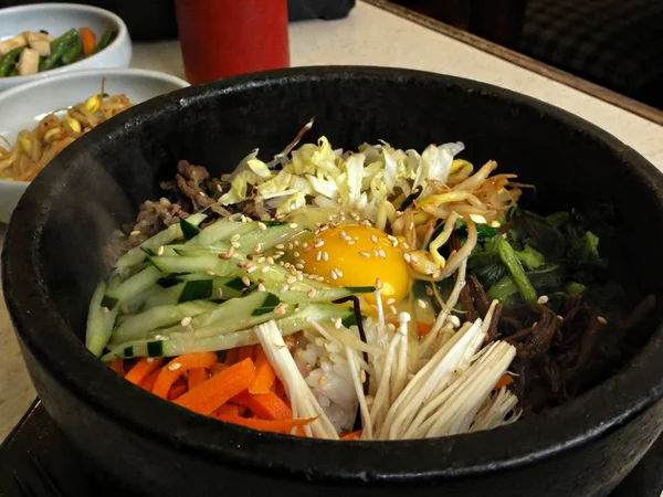 Bibimbap 是韩国传统的最爱 由蒸饭组成 上面有肉 蘑菇和蔬菜 通常放在热石锅里 — 图库照片