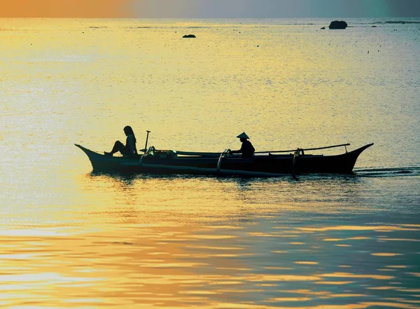 Silhouet van de vrouw en boot man in de boot bij zonsopgang — Stockfoto