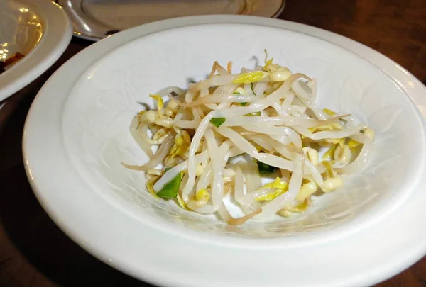 在白色圆盘上食用煮熟的豆芽开胃菜 — 图库照片