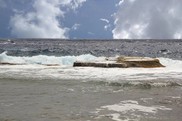 海岸線と紺碧の太平洋の巨大な波を分けて際立っている岩のプラットフォーム — ストック写真