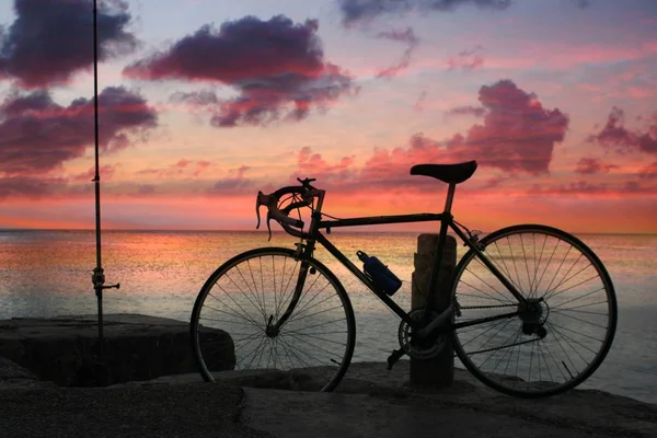 Silhouette Eines Fahrrads Das Neben Einem Steg Strand Vor Sonnenuntergang — Stockfoto