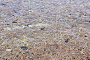 Tropik bir adada sığ bir plaj üzerinde akan dalgalar oluşturan kristal berraklığında sular