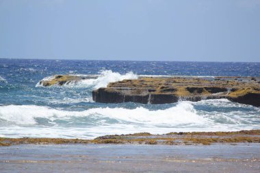 Suda düz bir keskin kayalık sahne karşı sıçrayan beyaz dalgalar Güzel deniz manzarası