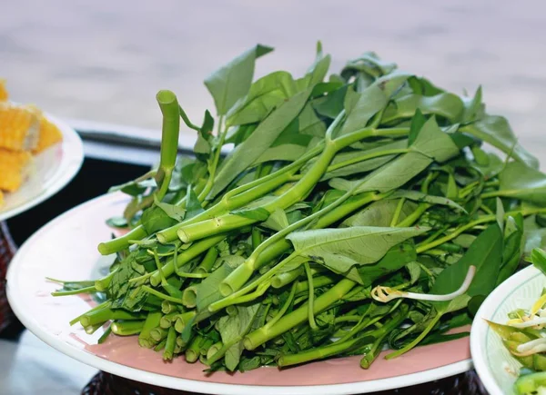 Kangkong veya su ıspanak taze hasat ve yuvarlak bir tabak yerleştirilir