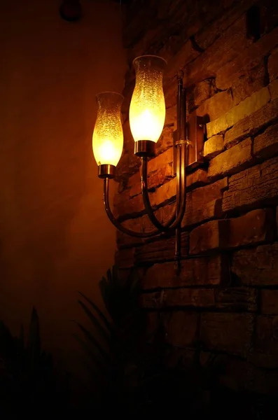 Dvojice Osvětlených Lamp Visených Pozadí Cihlové Zdi — Stock fotografie