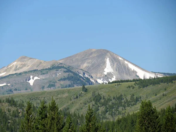 Aufwärtsschuss ferner Berge, die teilweise mit Schnee bedeckt sind — Stockfoto