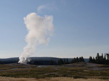 Wyoming 'deki Yellowstone Ulusal Parkı' nda buharlı ve kaynar su fışkıran Eski Sadık gayzerin geniş görüşü.