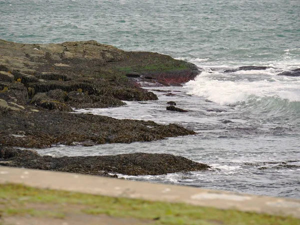 Las Olas Ruedan Hacia Las Rocas Cubiertas Musgo Una Playa —  Fotos de Stock