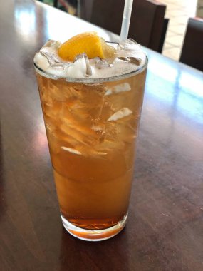 Üstünde limon dilimi olan bir bardak bira.