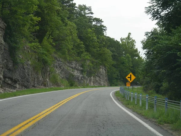 Tehlike uyarısı ve hız sınırı olan dolambaçlı yol