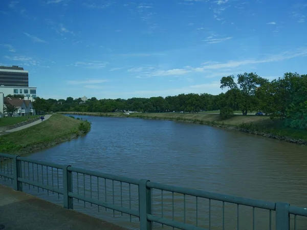 Orta geniş nehir manzaralı, yol kenarında çelik korkuluklar var.