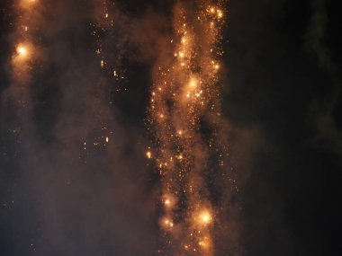 Karanlık gökyüzünde parlayan renkli havai fişeklere yakın.