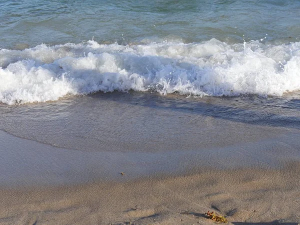 波が砕けて浜に模様を作る — ストック写真