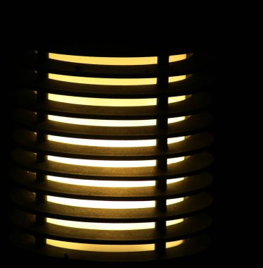 Close up of a lighted lampshade, dark background