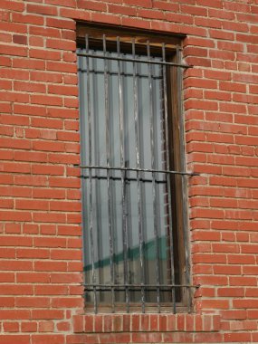Glass window with steel bars, brick wall
