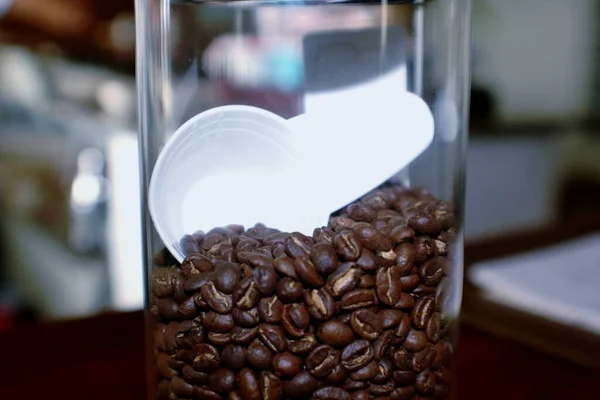 Koffiebonen Een Glazen Pot Met Een Witte Primeur — Stockfoto