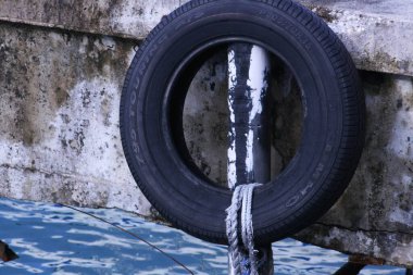 Close up of an old rubber tire used as a bouy near a dock