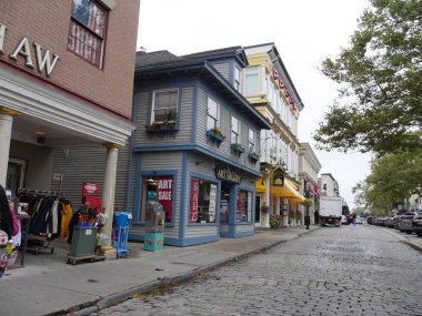 Newport, Rhode Island-September 2017:  Row of stores adn souvernir shops along the cobblestone street of Thames in Newport.