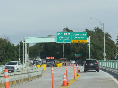 Newport, Rhode Island-September 2017: Directional signs with construction cone barriers on the road to the directions of Middletown, Portsmouth, and Downtown Newport.