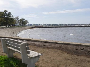 Newport, Rhode Island-September 2017: Cpncrete and wooden bench facing the beach area near the Newport Harbor.