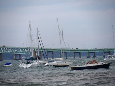 Newport, Rhode Island-September 2017: Windy day at the bay with sailboats in the water, Jamestown Bridge in the background.