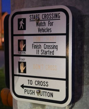 Close up of a sign at the pedestrian crosswalk in a highway.