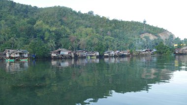 Filipinler 'in güney kesimindeki Punta Linao balıkçı köyündeki ağaçların üzerinde sıralanmış evler suya yansıdı..